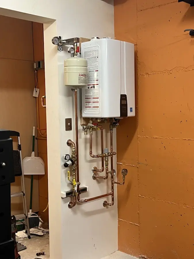Plumbing technician inspecting water heater connections in Lockland
